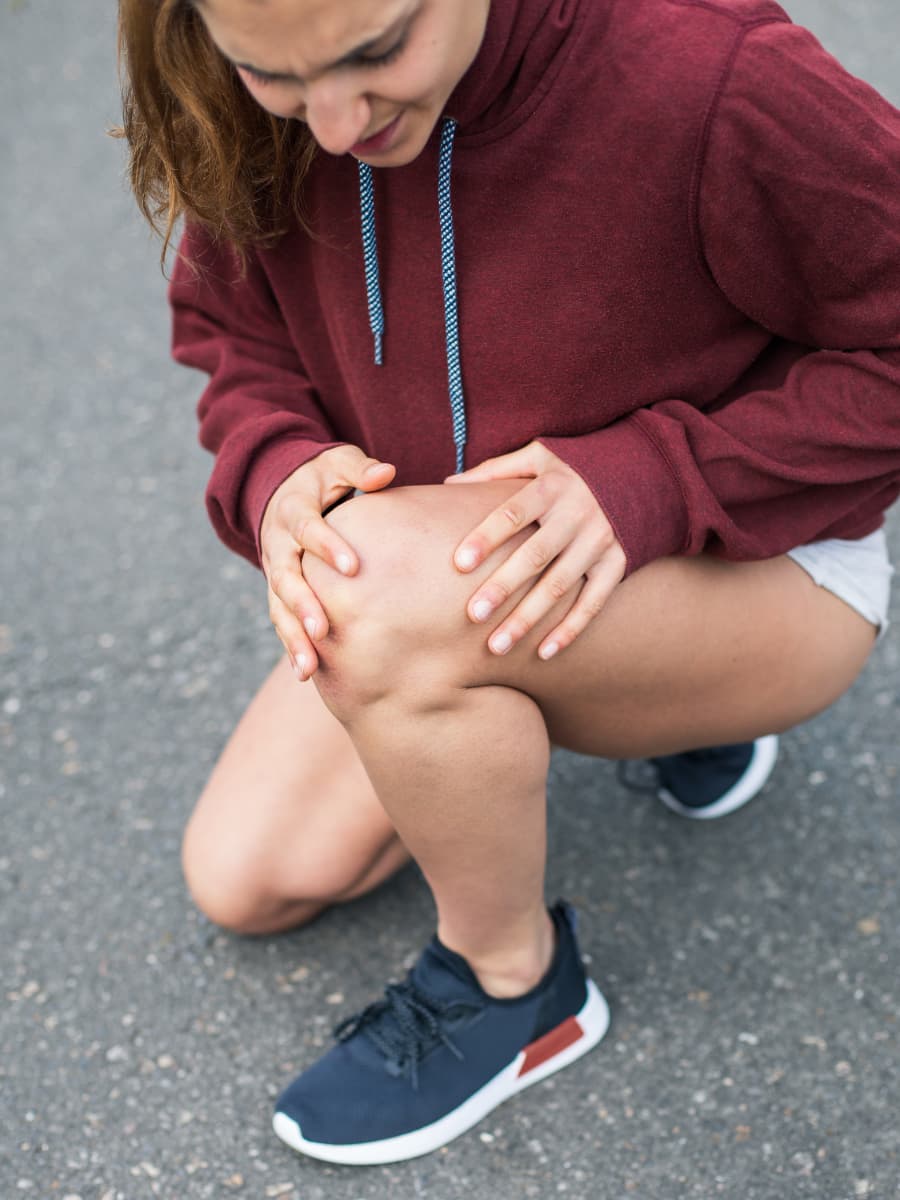 A woman clutching her knee in pain
